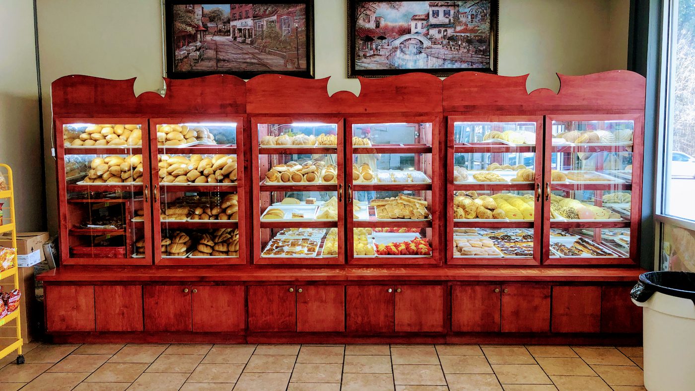 The red wooden display cases inside Celia's Bakery