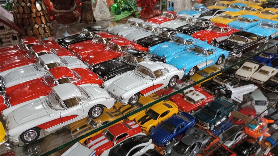 Rows of die-cast collectible model cars on a shelf