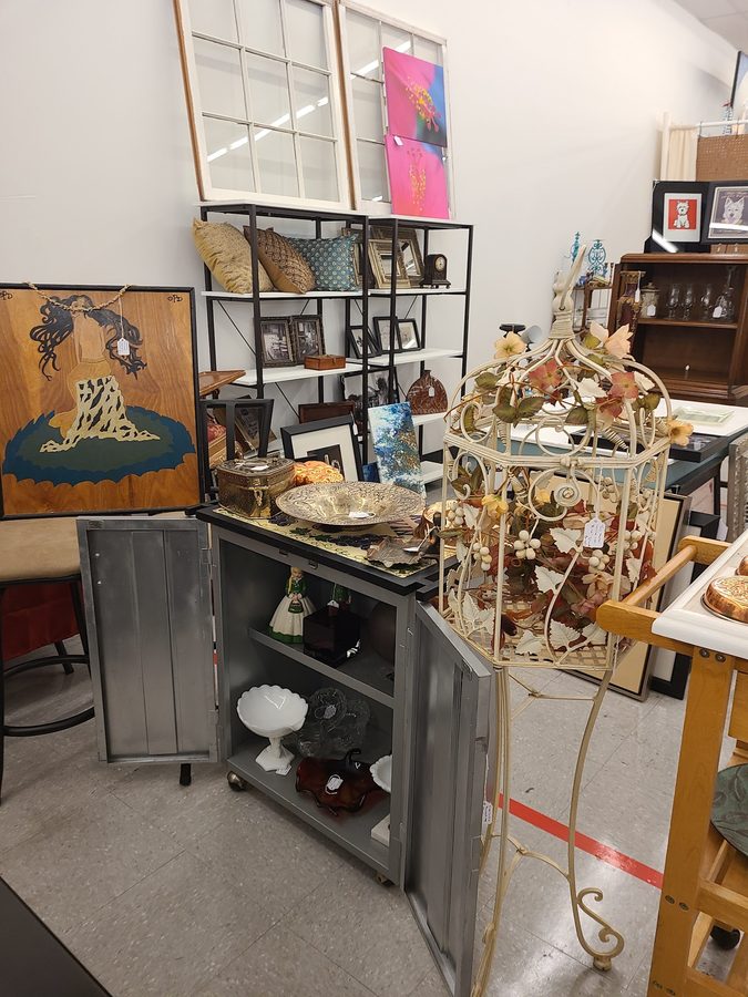 Open shelving with framed art, glassware, pillows and decorative pieces