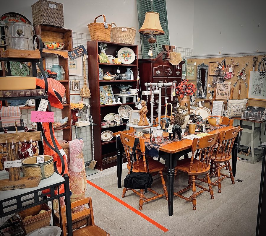 An interior vignette of antique furniture, dishware and a jewelry display inside Finders Keepers OS