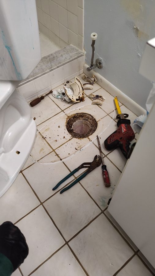 Mid-repair close-up of plumbing work with tools laid out