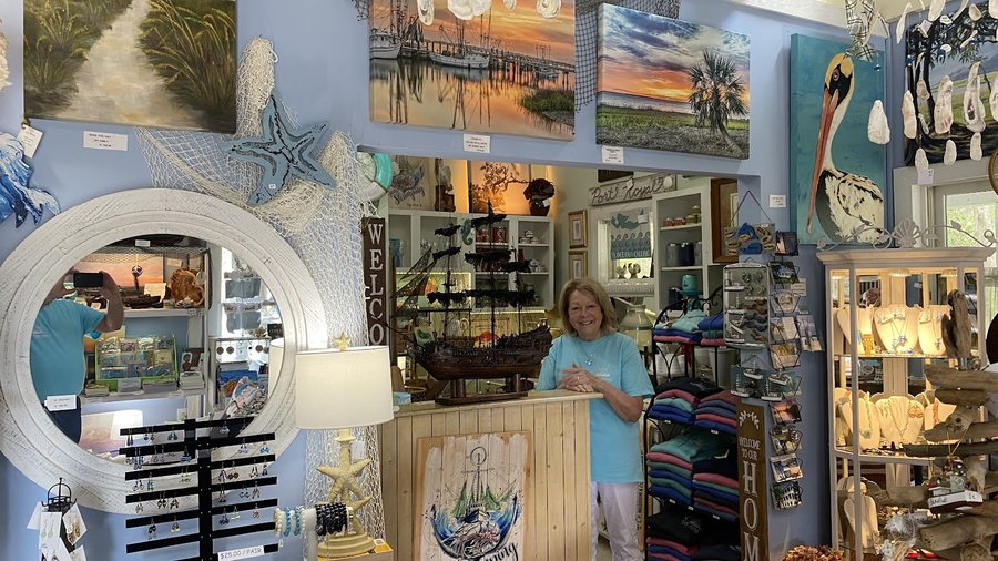 Inside Mrs. B & Company: a staffed counter with jewelry racks, local art, and a welcoming Port Royal retail floor.