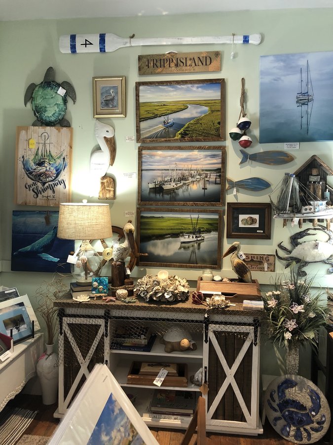 Coastal home decor: a sea-turtle sculpture and whale wall art on a shop display wall.