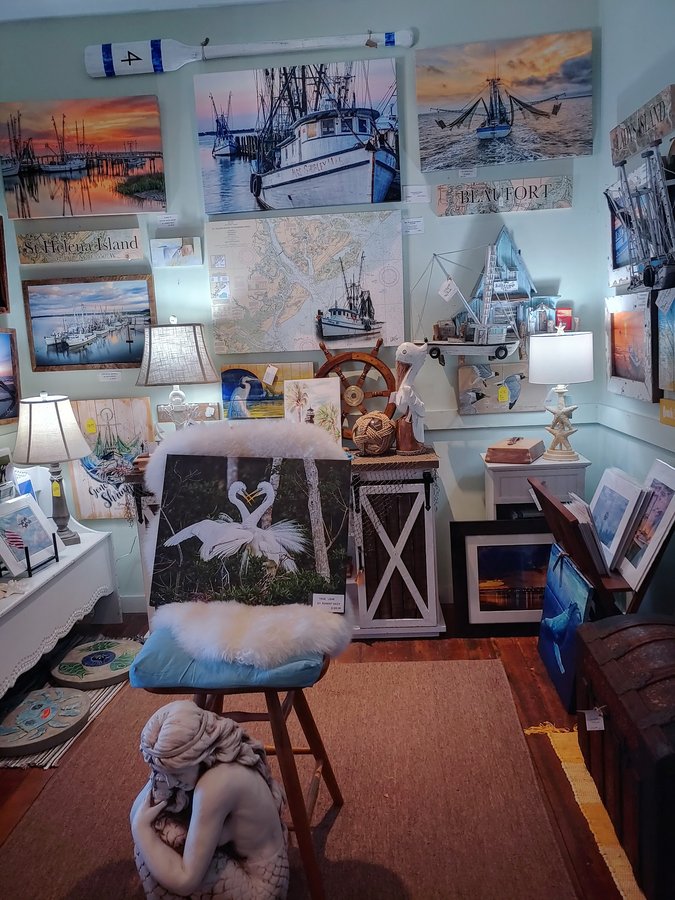 A curated gallery wall of framed Lowcountry shrimp-boat photography and coastal art.