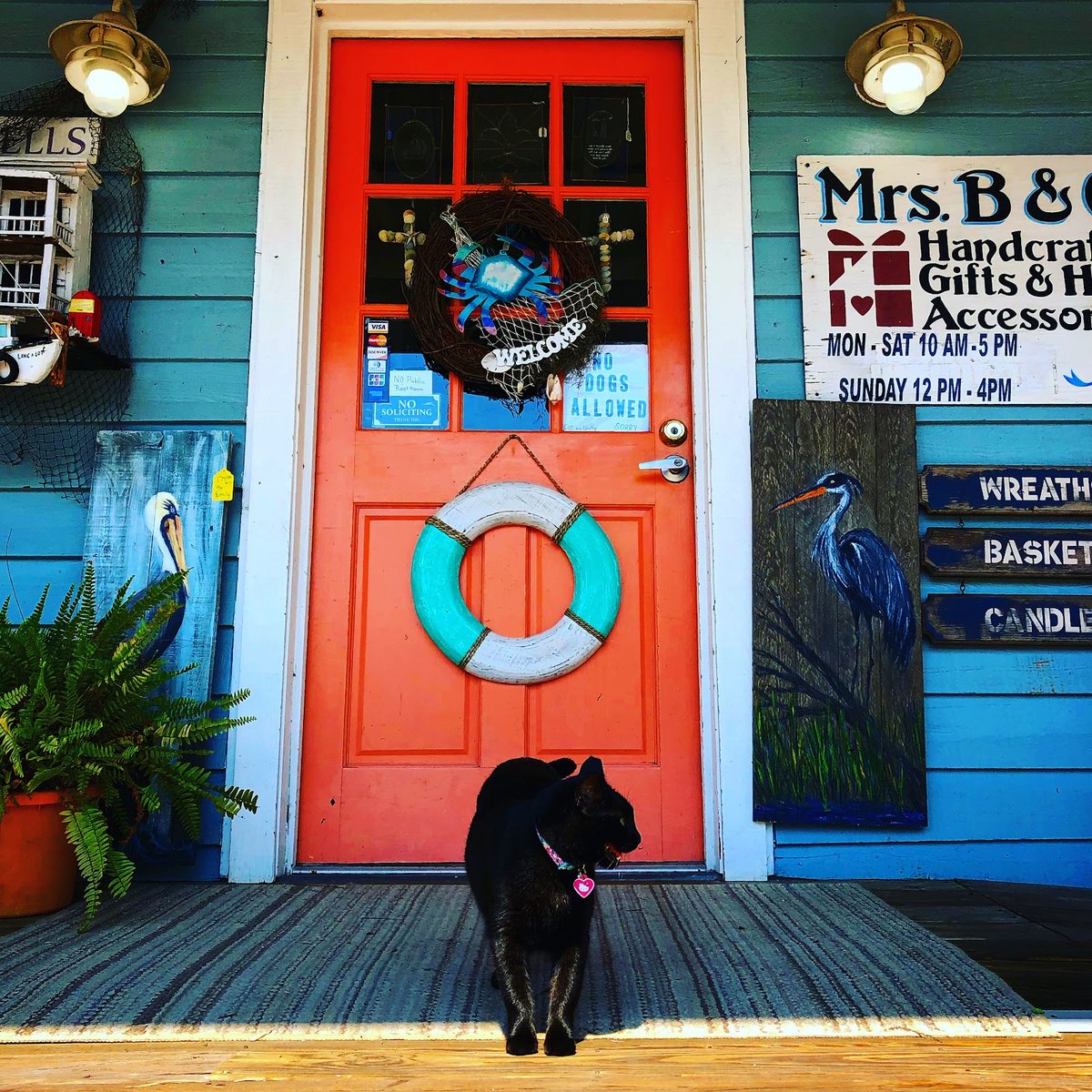 The Mrs. B & Company storefront: bright orange door, hand-painted signage, and posted shop hours.