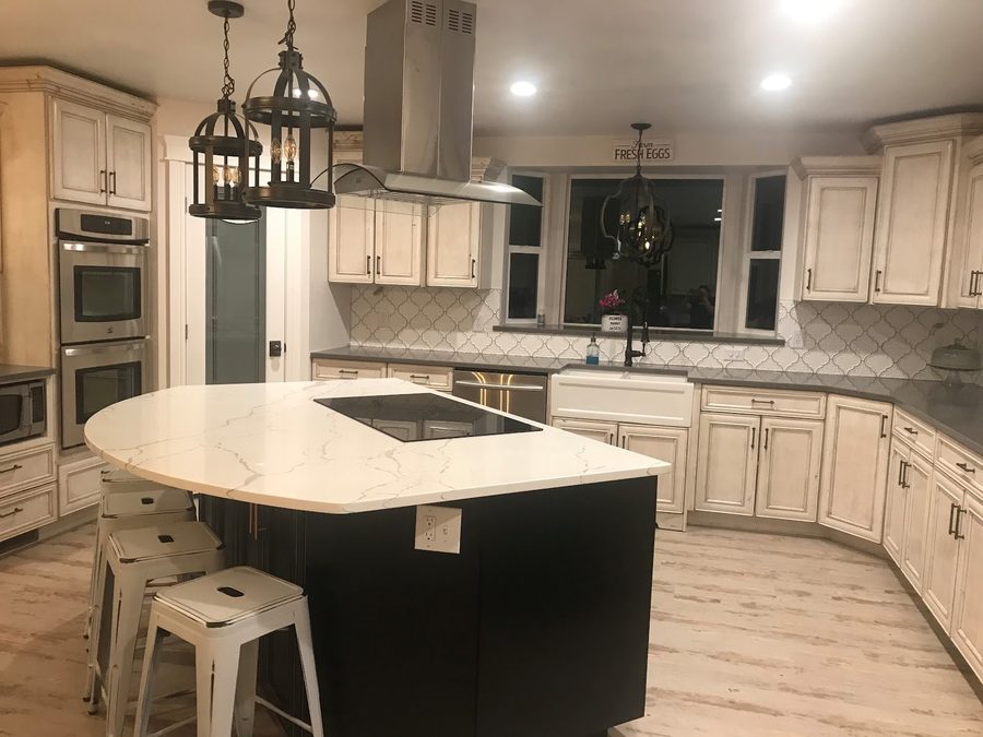 Finished kitchen remodel with white shaker cabinets and a quartz island