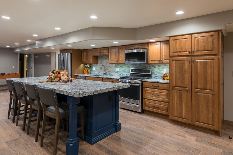 Finished kitchen remodel with stained wood cabinets and a navy island base