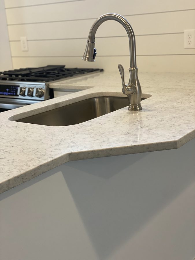 Close-up of a finished quartz countertop with undermount sink and faucet