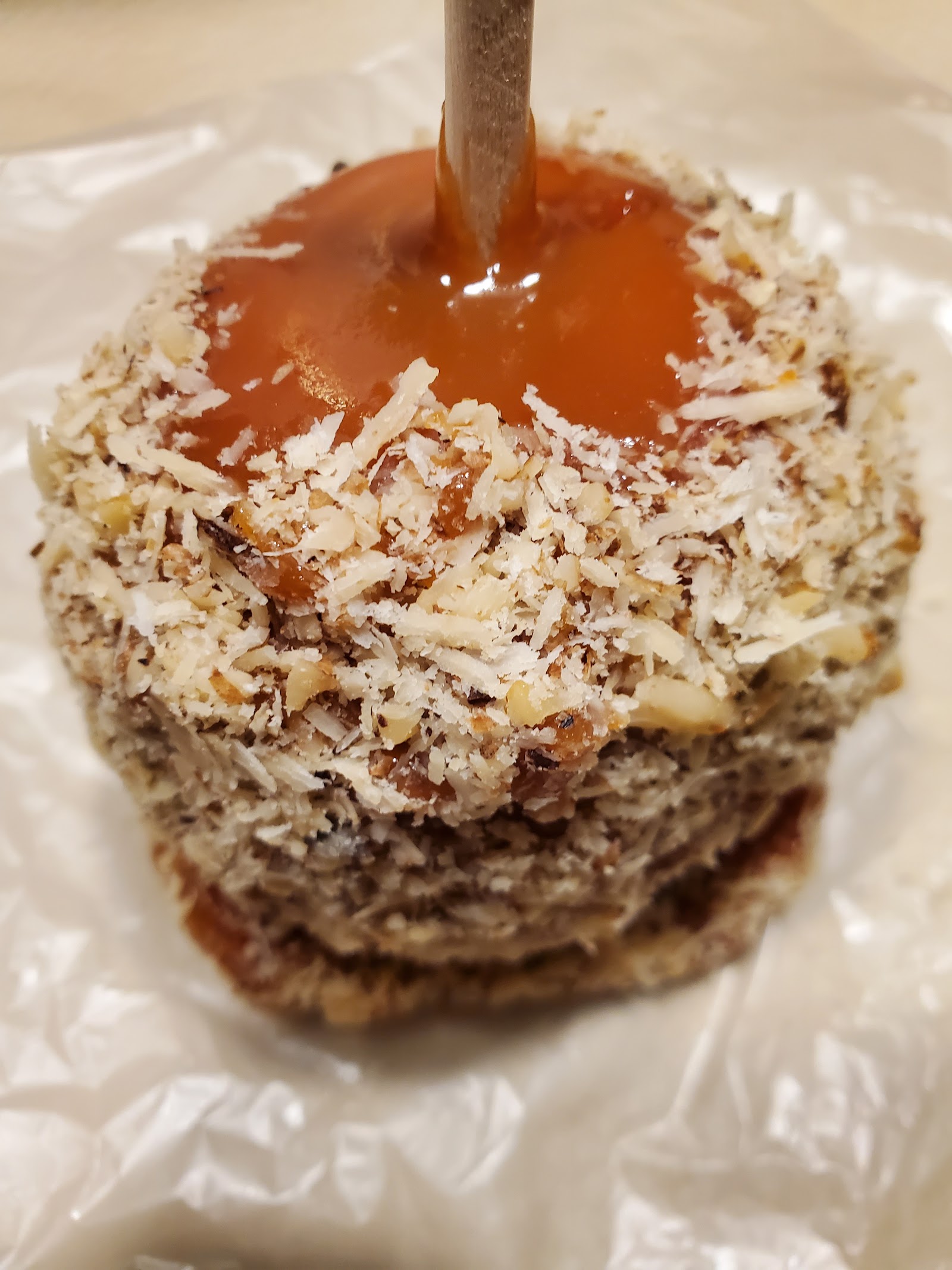 Hand-dipped caramel apple rolled in coconut and nuts
