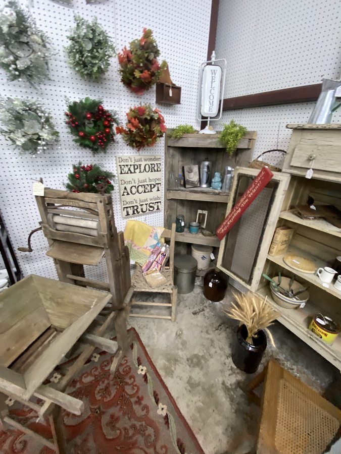 A vendor booth with seasonal decor, vintage tools, a wringer washer and collectibles.