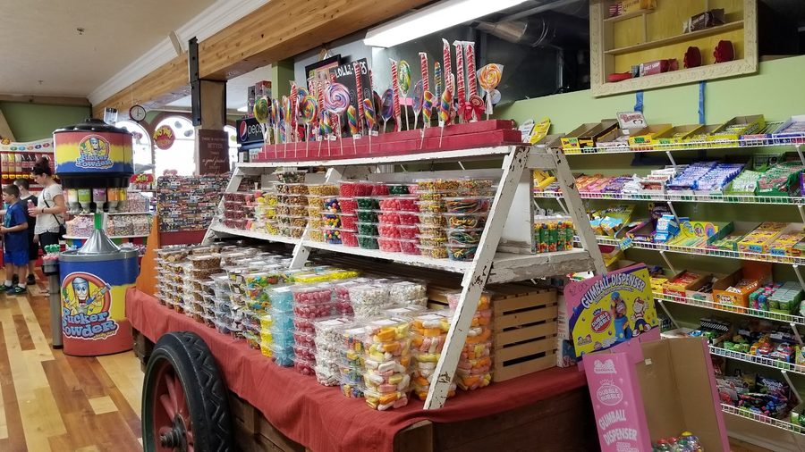 Interior of Aunt Millie's candy store with lollipop cart and candy shelves