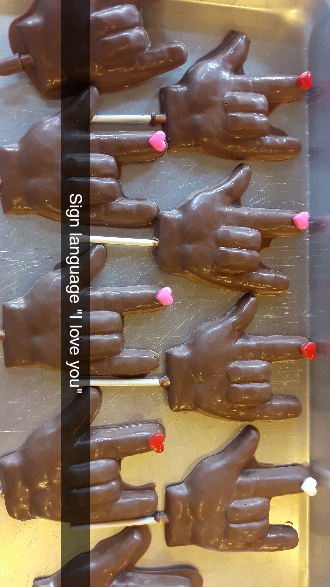 Chocolate hand-shaped pops on a baking tray, made in the shop